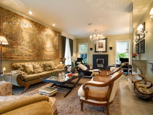 Biblioteca do Hotel Boutique em Campos do Jordão, poltronas e sofá em uma sala com lareira