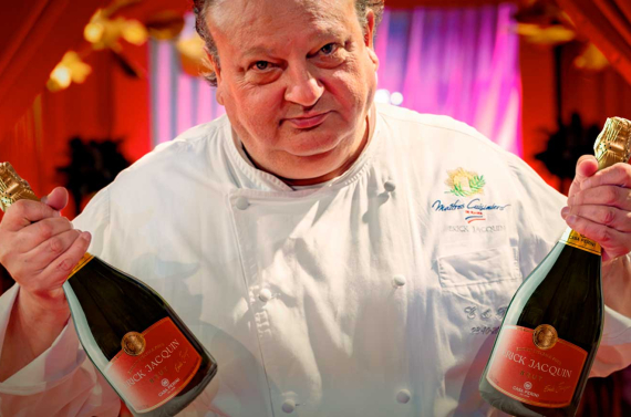 Foto mostra o chef Érick Jacquin segurando duas garrafas do novo espumante em parceria com a Casa Perini