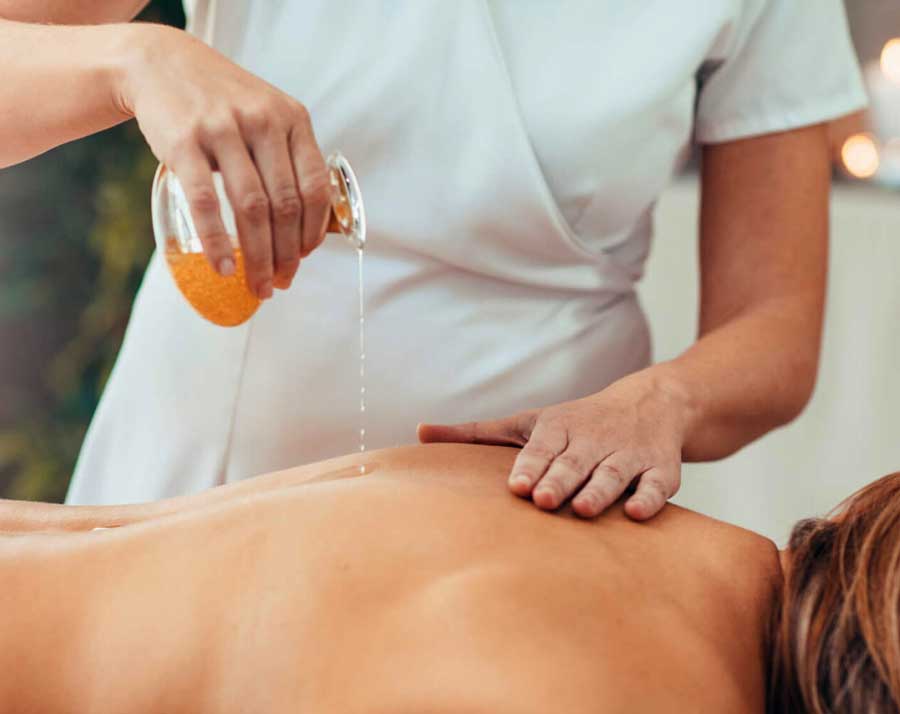 Imagem mostra uma mulher branca recebendo massagem
